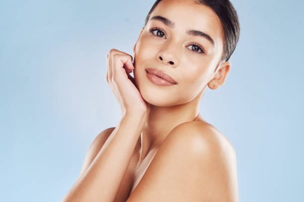 Closeup face beautiful young mixed race woman. An attractive female posing in studio isolated against a blue background. A skincare regime that keeps your skin soft, smooth, glowing and healthy